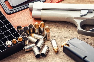 9 mm tabanca tabanca mermi ve şarjör ahşap arka plan üst görünümü üzerine serpiştirilmiş