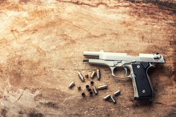 9 mm pistol gun bullets and magazine   strewn on the wooden background top view