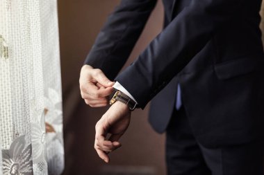 İş adamı ceket giyiyor, erkek eli kapalı, damat düğün töreninden önce hazırlanıyor.