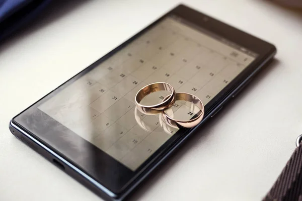 Beautiful gold wedding rings lie on the phone