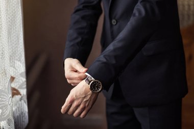 İş adamı ceket giyiyor, erkek eli kapalı, damat düğün töreninden önce hazırlanıyor.
