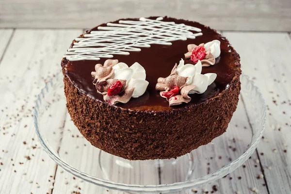 Dark chocolate vegan cake with cherries on wooden background