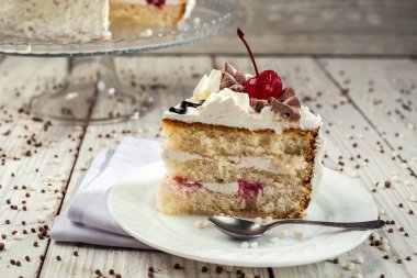 Bisküvi kek krem ve kiraz ahşap arka plan üzerinde