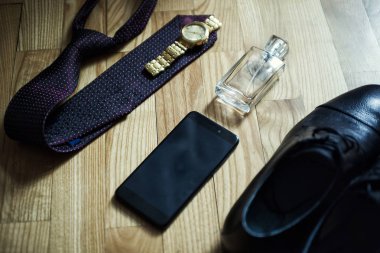 Farklı Erkek aksesuarlar gibi: ayakkabı, kravat, saatler, parfum ve telefon - ahşap arka plan üzerinde vardır