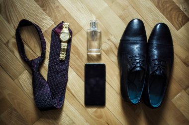 Farklı Erkek aksesuarlar gibi: ayakkabı, kravat, saatler, parfum ve telefon - ahşap arka plan üzerinde vardır