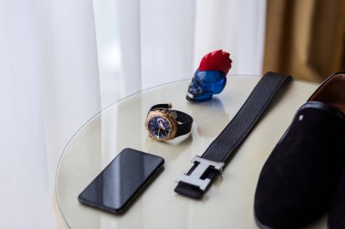 Farklı Erkek aksesuarlar gibi: ayakkabı, kemer, saatler ve telefon - masada vardır