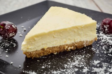 Siyah plaka üzerinde çilek ile klasik New York cheesecake. Tatlı kavramı 