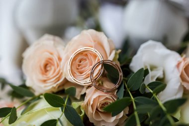 Alyanslar düğün aksesuarları gibi güzel bir buketin üzerinde yatıyor.