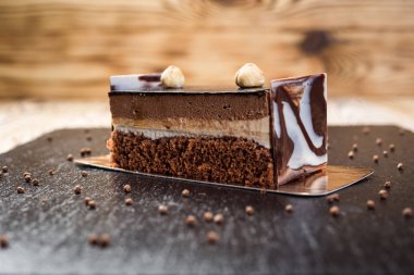 Koyu çikolata vegan kek şekerler ve ahşap zemin üzerine fındık