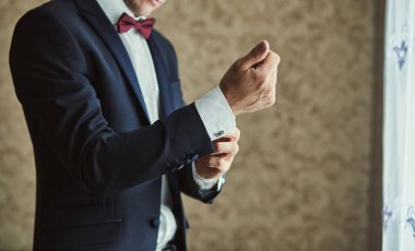 İş adamı ceket giyiyor, erkek eli kapalı, damat düğün töreninden önce hazırlanıyor.