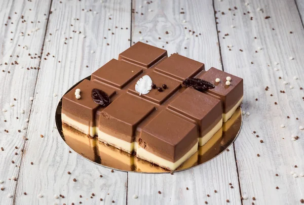 Dark chocolate vegan cake with candies on wooden background