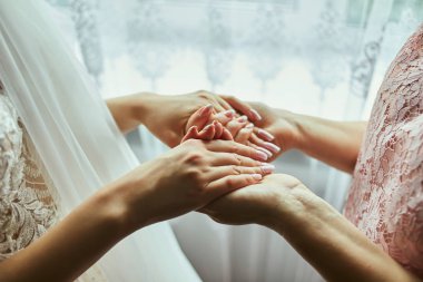 Düğün günü annesinin elini tutan bir gelin. Anneler ve kızlar arasındaki ilişki kavramı