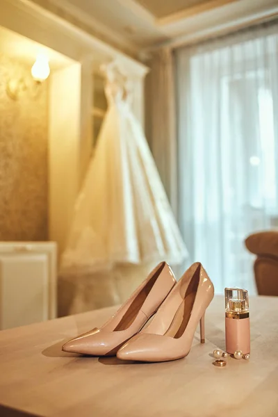 Bride\'s wedding accessories such as high heel shoes, earrings and perfume
