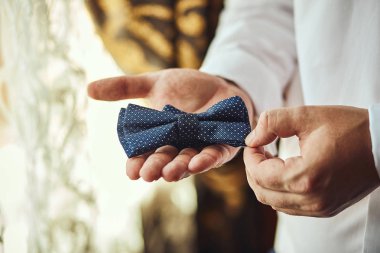 İş adamı papyon takıyor, kelebek kıyafeti giyiyor, damat düğün töreninden önce hazırlanıyor. Erkekler Moda