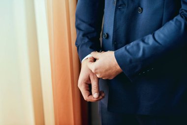 İşadamı takıyor bir ceket, Erkek eller closeup, damat düğün töreni önce sabah hazırlanıyor. Erkek moda