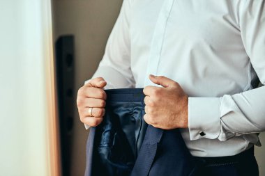 İşadamı takıyor bir ceket, Erkek eller closeup, damat düğün töreni önce sabah hazırlanıyor. Erkek moda