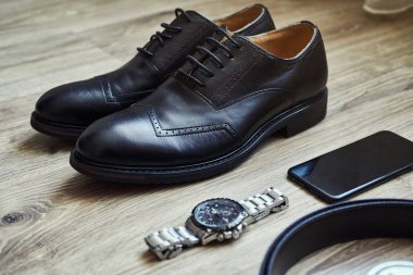 Bir iş adamının farklı aksesuarları ahşap bir arka planda yatar.