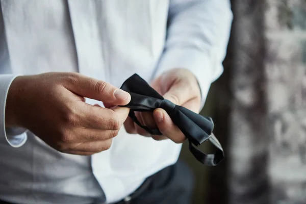 businessman putting on  bow tie,man butterfly clothes,groom getting ready in the morning before wedding ceremony