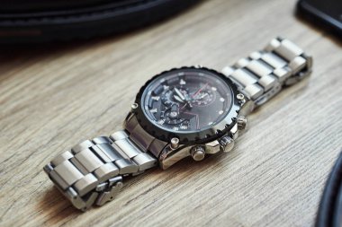 Bir iş adamının farklı aksesuarları ahşap bir arka planda yatar.