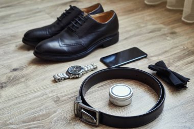 Bir iş adamının farklı aksesuarları ahşap bir arka planda yatar.