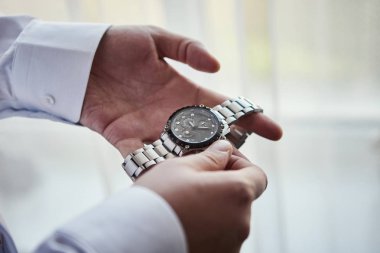İş adamı kol saatini kontrol ediyor, saati eline alıyor, damat düğün töreninden önce hazırlanıyor. Erkekler Moda