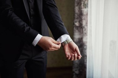 İş adamı ceket giyiyor, erkek eli kapalı, damat düğün töreninden önce hazırlanıyor.
