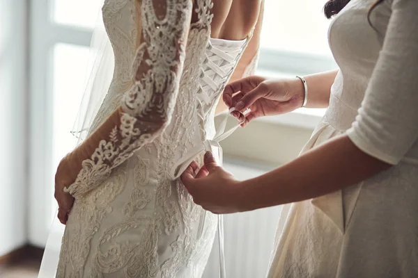 Manhã da noiva quando ela usa um vestido bonito, mulher se preparando antes da cerimônia de casamento — Fotografia de Stock