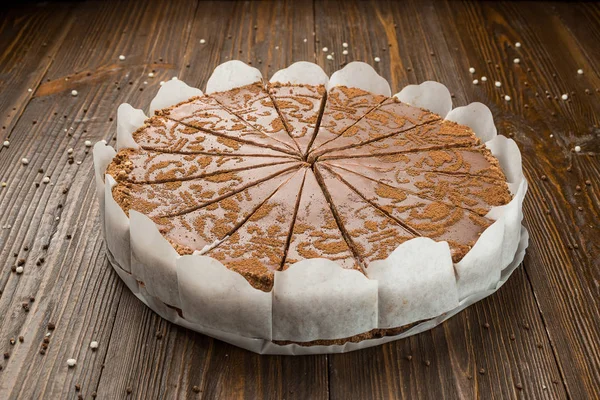 Donkere chocolade vegan cake met snoepjes en noten op houten achtergrond — Stockfoto