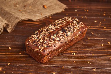 Ahşap arka planda tüm buğday zanaat ekmek. Sağlıklı gıda ve geleneksel fırın kavramı. Rustik