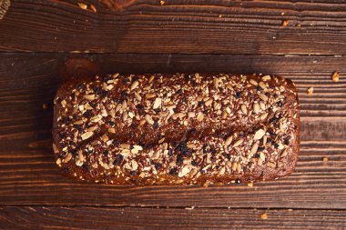 Ahşap arka planda tüm buğday zanaat ekmek. Sağlıklı gıda ve geleneksel fırın kavramı. Rustik