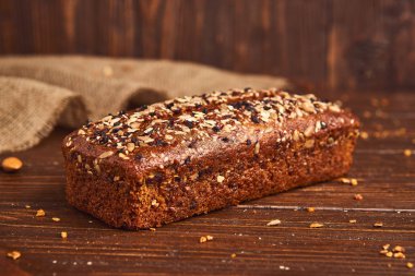 Ahşap arka planda tüm buğday zanaat ekmek. Sağlıklı gıda ve geleneksel fırın kavramı. Rustik