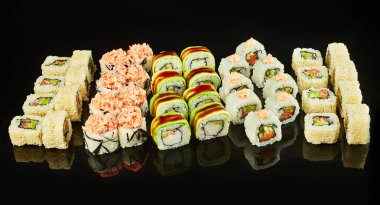 Menü için siyah arka planda izole lezzetli suşi rulo çeşitli. Japon yemekleri
