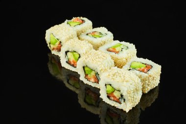 Menü için siyah arka planda somon ve avokado ile klasik rulo suşi. Japon yemekleri