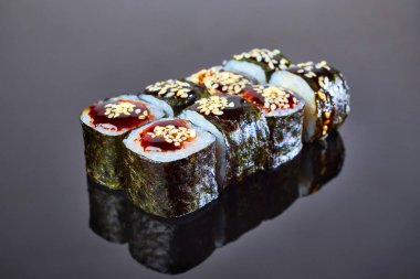 Menü için siyah arka plan üzerinde füme eel ile Klasik rulo suşi. Japon yemekleri