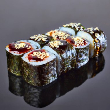 Menü için siyah arka plan üzerinde füme eel ile Klasik rulo suşi. Japon yemekleri