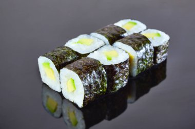 Menü için siyah arka plan üzerinde avokado ile Klasik vegan rulo suşi. Japon yemekleri