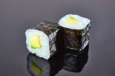 Menü için siyah arka plan üzerinde avokado ile Klasik vegan rulo suşi. Japon yemekleri