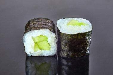 Menü için siyah arka plan üzerinde salatalık ile Klasik vegan rulo suşi. Japon yemekleri