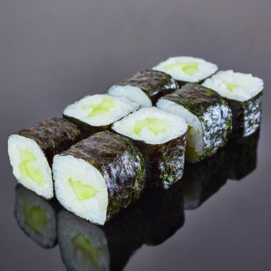 Menü için siyah arka plan üzerinde salatalık ile Klasik vegan rulo suşi. Japon yemekleri