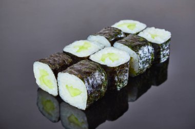 Menü için siyah arka plan üzerinde salatalık ile Klasik vegan rulo suşi. Japon yemekleri