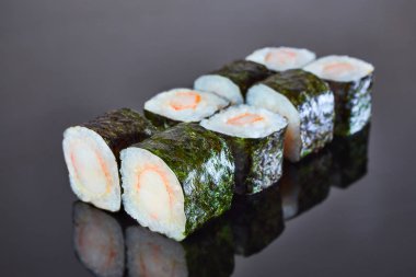Menü için siyah zemin üzerinde yengeç çubukları olan klasik rulo suşi. Japon yemeği.