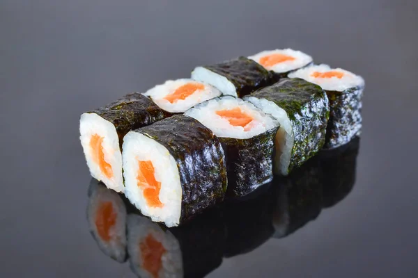 Classical roll sushi with salmon on black background for menu. Japanese food