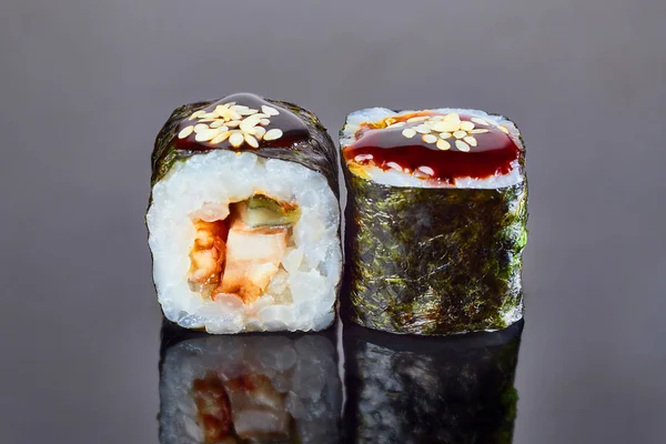 Klassisches Rollsushi mit geräuchertem Aal auf schwarzem Hintergrund als Menü. japanisches Essen — Stockfoto