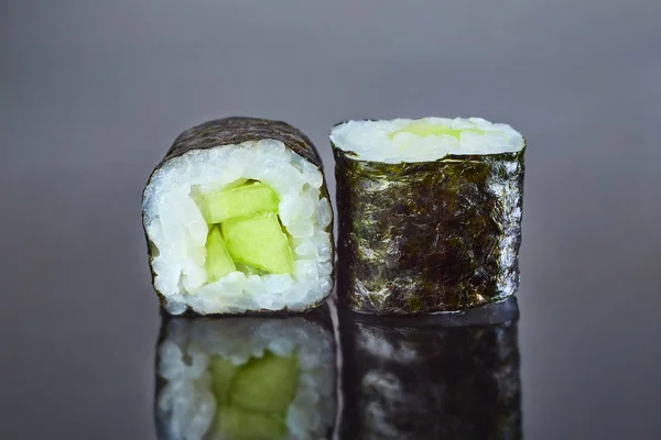 メニューのための黒の背景にキュウリと古典的なビーガンロール寿司。日本食 — ストック写真