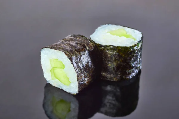 メニューのための黒の背景にキュウリと古典的なビーガンロール寿司。日本食 — ストック写真