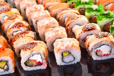 Menü için siyah arka plan lezzetli suşi rulo çeşitli. Japon yemekleri