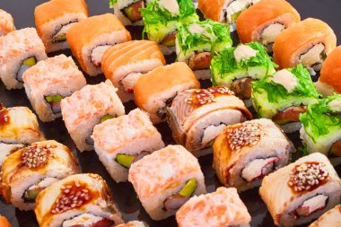 Menü için siyah arka plan lezzetli suşi rulo çeşitli. Japon yemekleri