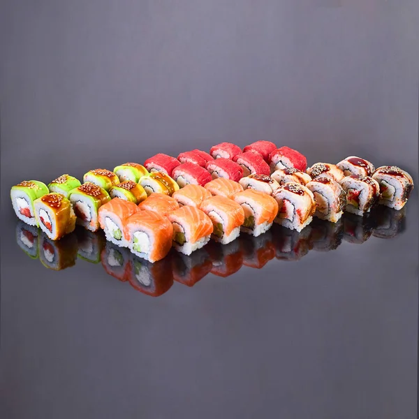 Vários tipos de rolo de sushi saboroso no fundo preto para o menu. Comida japonesa — Fotografia de Stock