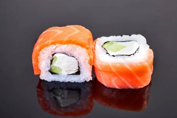 Philadelphia roll sushi with salmon, avocado and cream cheese on black background for menu. Japanese food — Stock Photo, Image