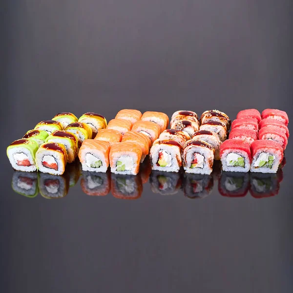 Various kinds of tasty sushi roll on black background for menu. Japanese food — Stock Photo, Image